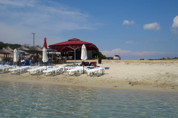 Ένα μέρος της παραλίας των Αλυκών στο νησί Αμμουλιανή με ομπρέλες, ξαπλώστρες και εγκαταστάσεις beach bar.