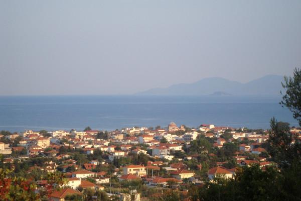 Μια πανοραμική φωτογραφία που απεικονίζει τα σπίτια της Ασπροβάλτας με φόντο τη θάλασσα και τα βουνά.