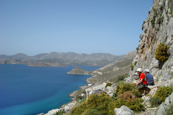 Δύο ορειβάτες από έναν απότομο βράχο στο νησί της Καλύμνου και το απέραντο γαλάζιο της θάλασσας στο βάθος.