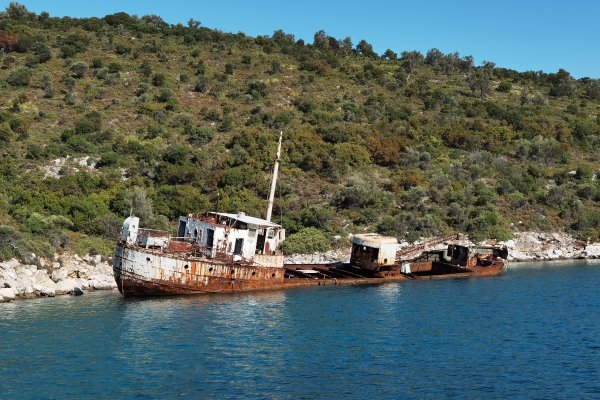 Ένα σκουριασμένο ναυάγιο βυθισμένο εν μέρει στη βραχώδη ακτή της Περιστέρας.