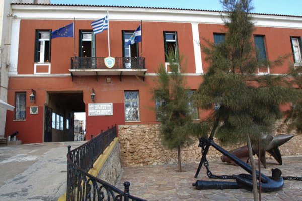 Το Ναυτικό Μουσείο Κρήτης είναι ένα κόκκινο μονώροφο κτίριο με μια μεγάλη άγκυρα στην αυλή του.
