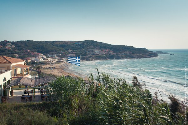 Μια ταβέρνα, ένα σπίτι, η παραλία και η θάλασσα του Αρίλλα κάτω από μιά ελληνική σημαία.