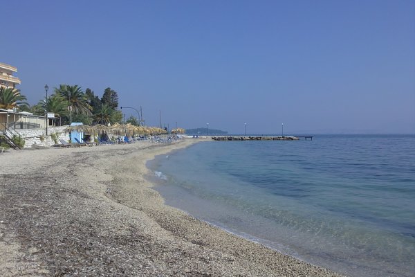 Βότσαλα και καθαρά νερά κάτω από τον γαλάζιο ουρανό στην παραλία Μπενίτσες, Κέρκυρα.