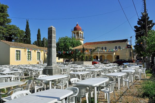 Ο περίβολος της εκκλησίας των Γουβιών γεμάτος τραπέζια και καρέκλες στις προετοιμασίες του τοπικού πανηγυριού.