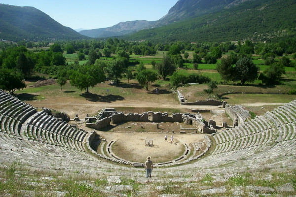 Πανοραμική θέα στο αρχαίο θέατρο της Δωδώνης με φόντο την καταπράσινη κοιλάδα και τα γύρω βουνά.