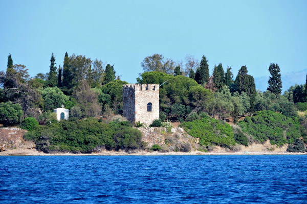 Μια φωτογραφία του Ενετικού Πύργου στην ακτή του νησιού της Αγίας Τριάδας μεσα στην πυκνή βλάστηση.
