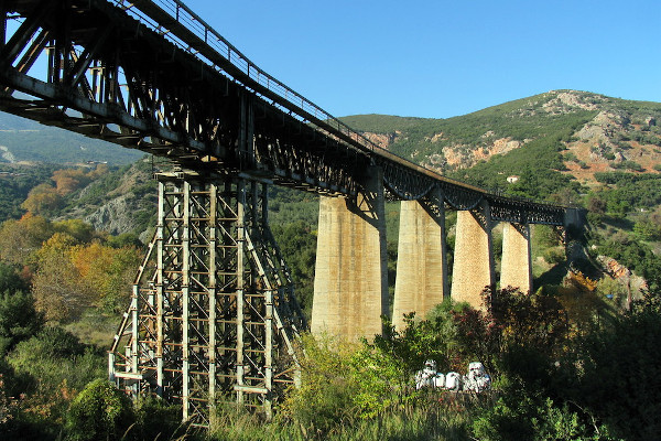 Μια φωτογραφία της Γέφυρας του Γοργοπόταμου με τσιμεντένιους στύλους, εκτός από έναν που είναι φτιαγμένος από ατσάλι.