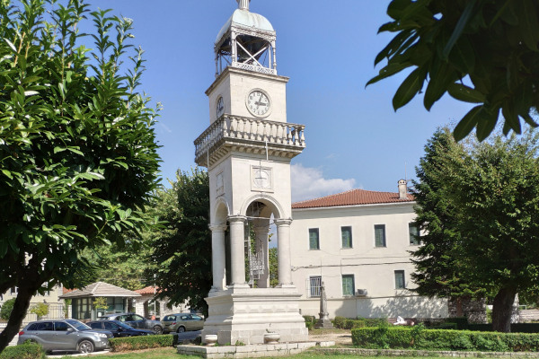 Ο Πύργος του Ρολογιού των Ιωαννίνων ανάμεσα στα δέντρα της πλατείας Δημοκρατίας.