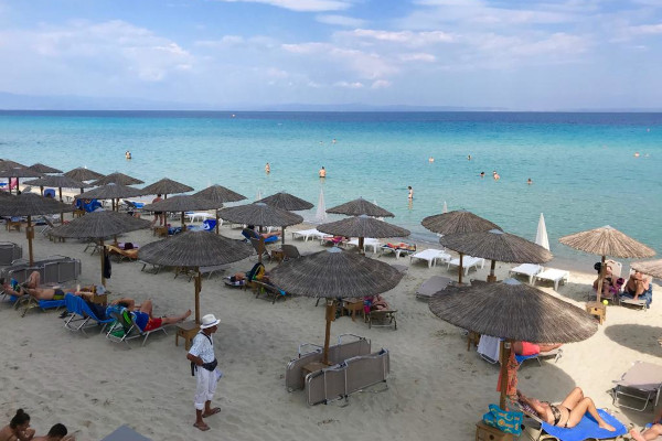 Πολυάριθμες ομπρέλες και ξαπλώστρες στην παραλία της Καλλιθέας της Χαλκιδικής.