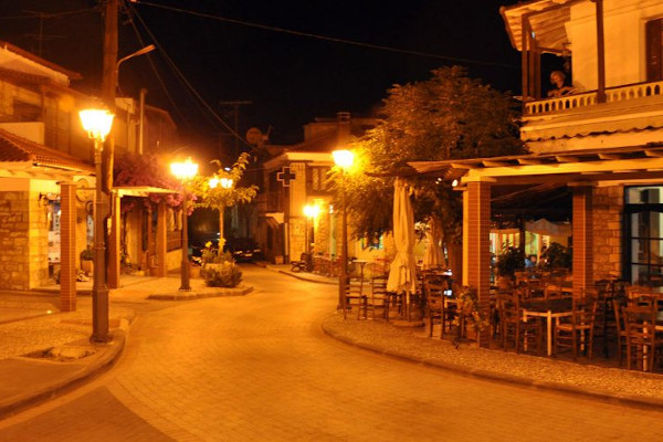 Νυχτερινή θέα σε έναν κεντρικό δρόμο του Παλιούρι, όπου υπάρχει μια ταβέρνα και άλλα καταστήματα.