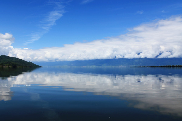 Τα νερά της λίμνης Κερκίνη αντανακλούν τα σύννεφα και τον γαλάζιο ουρανό.