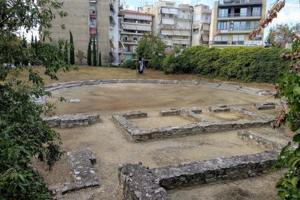 Τα ερείπια του αρχαίου θεάτρου της Λάρισας με φόντο πολυκατοικίες.