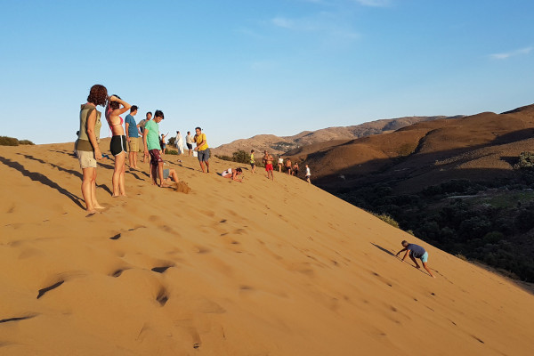 Ομάδα ατόμων στην περιοχή Αμμοθίνες της Λήμνου πάνω σε αμμόλοφο.