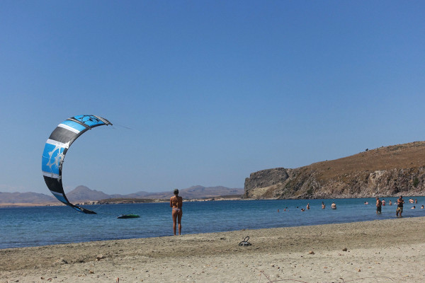 Μια εικόνα της παραλίας του Χαβούλη με μερικούς ανθρώπους και kite surfing.