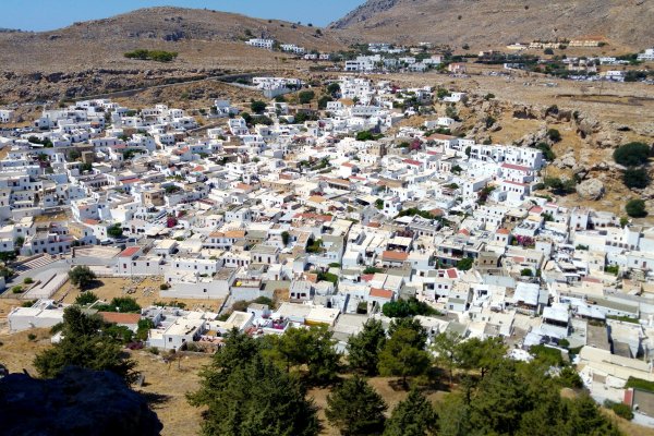 Αεροφωτογραφία της Λίνδου γεμάτη λευκά σπίτια σε ένα άγονο τοπίο.