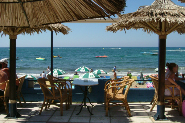 Μια φωτογραφία τραβηγμένη από τη βεράντα ενός beach bar που δείχνει την παραλία των Μαλίων.