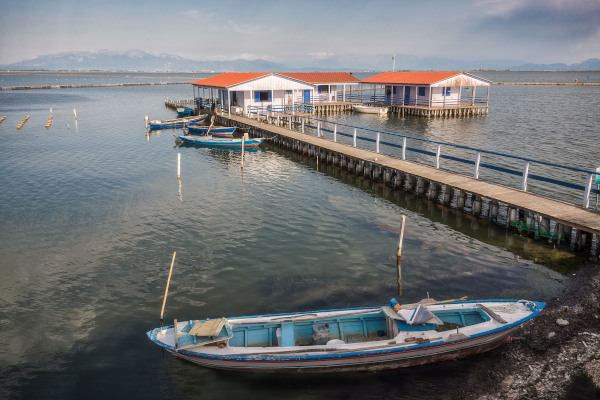 Αλιευτικές καλύβες, μια γέφυρα και μια βάρκα στη λιμνοθάλασσα του Μεσολογγίου.