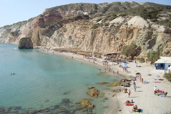 Ένας γκρεμός που οδηγεί σε μια παραλία, θάλασσα με καταπράσινα νερά και ένα beach bar στον κόλπο της Φυριπλάκας.