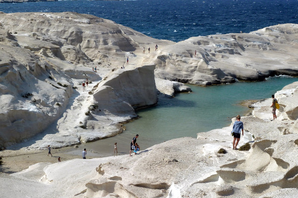 Άνθρωποι που περπατούν σε ασβεστολιθικούς βράχους και γκρεμούς της παραλίας Σαρακίνικο στη Μήλο.
