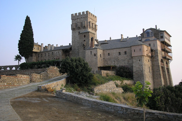 Ο δρόμος που οδηγεί στην κύρια είσοδο της Μονής Σταυρονικήτα και το εξωτερικό του μοναστηριού με αμυντικό πύργο.
