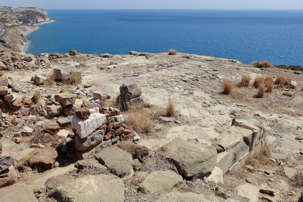 Απομεινάρια του Αρχαιολογικού Χώρου Πύργος Μύρτος με φόντο τη γαλάζια θάλασσα.