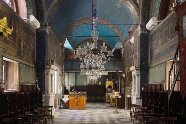 Το εσωτερικό μιας αψιδωτής εκκλησίας με μπλε οροφή και αγιογραφίες - Ναός Αγίου Σπυρίδωνα, Ναύπλιο.