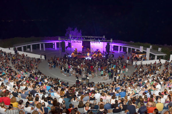 Το κοινό και το συγκρότημα στη σκηνή κατά τη διάρκεια συναυλίας στο αμφιθέατρο των Νέων Μουδανιών.