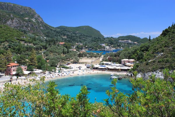Η παραλία Αγίου Σπυρίδωνα ή Παλεοκαστρίτσα με γαλαζοπράσινα νερά περιβάλλεται από καταπράσινους, βραχώδεις λόφους.