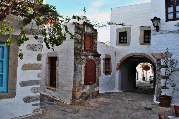 Μια φωτογραφία τραβηγμένη σε έναν από τους δρόμους στη Χώρα της Πάτμου ανάμεσα στα παραδοσιακά κτίρια.