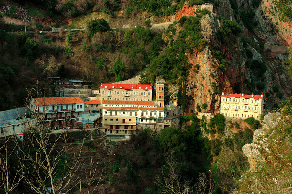 Μια φωτογραφία  της Μονής Προυσού που είναι χτισμένη στους βράχους του βουνού.