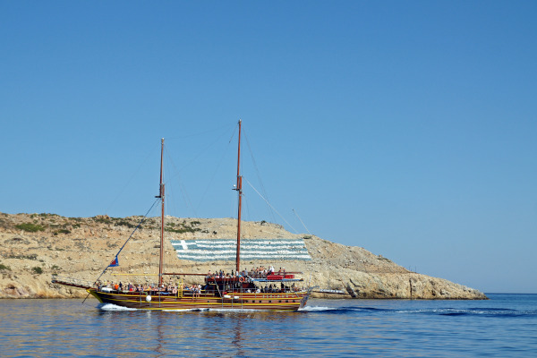 Κρουαζιερόπλοιο στις ακτές του νησιού Ψέριμος και η ελληνική σημαία που ζωγράφησαν στη στεριά.