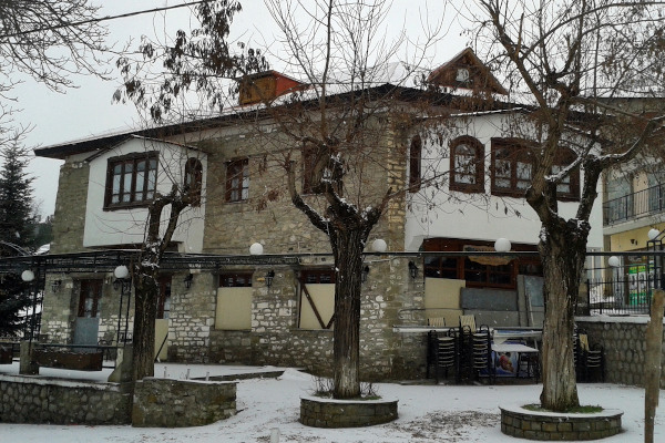 Ένα κτίριο παραδοσιακής ορεινής αρχιτεκτονικής στη χιονισμένη πλατεία της Σαμαρίνας.