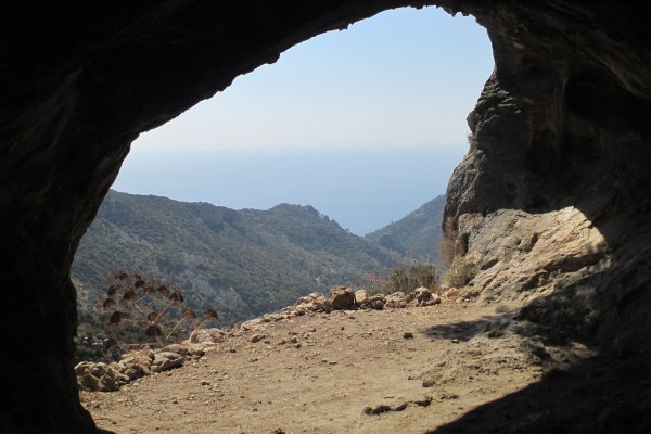 Η θέα των βουνών και της θάλασσας σε απόσταση από το εσωτερικό της σκοτεινής σπηλιάς του Πυθαγόρα.