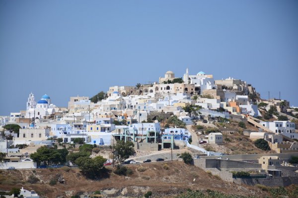 Ένας λόφος καλύπτεται με λευκά σπίτια και μερικούς μπλε τρούλους εκκλησιών.