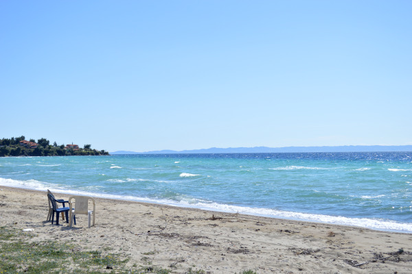 Μια φωτογραφία που δείχνει μερικές πλαστικές καρέκλες και ένα μέρος της παραλίας της Νικήτης Χαλκιδικής.