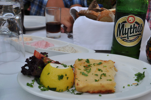 Το περίφημο σαγανάκι ως ορεκτικό και μια ελληνική μπύρα Μυθος σε ένα τραπέζι ενός εστιατορίου.