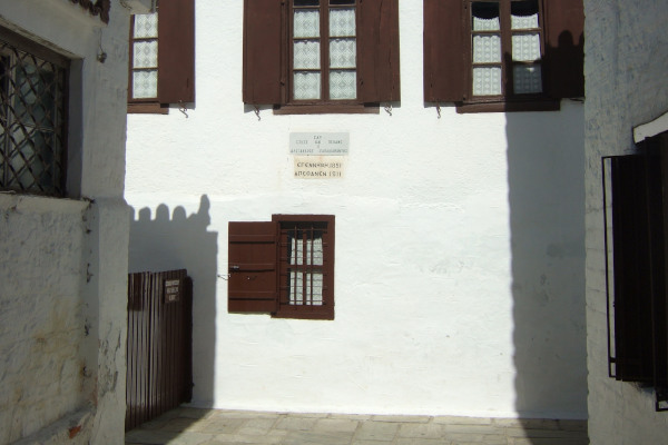 Το μπροστινό μέρος του Οίκου - Μουσείου Παπαδιαμάντη με επιγραφή στον τοίχο που ενημερώνει για τον τόπο.