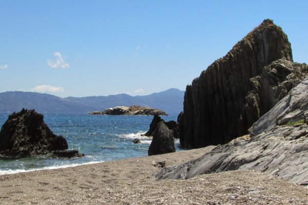 Γκρίζοι βράχοι και ογκόλιθοι στην άμμο και στη θάλασσα στην παραλία Ξάνεμος στη Σκιάθο.