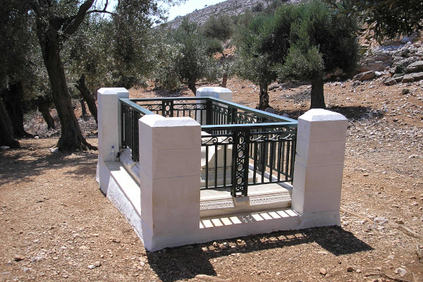 Ο τάφος του Ρούπερτ Μπρουκ από λευκό μάρμαρο είναι περιφραγμένος και περιβάλλεται από ελαιόδεντρα.