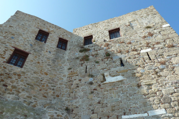 Οι ψηλοί πετρόχτιστοι τοίχοι της Μονή Αγίου Γεωργίου της Σκύρου με λίγα παράθυρα.
