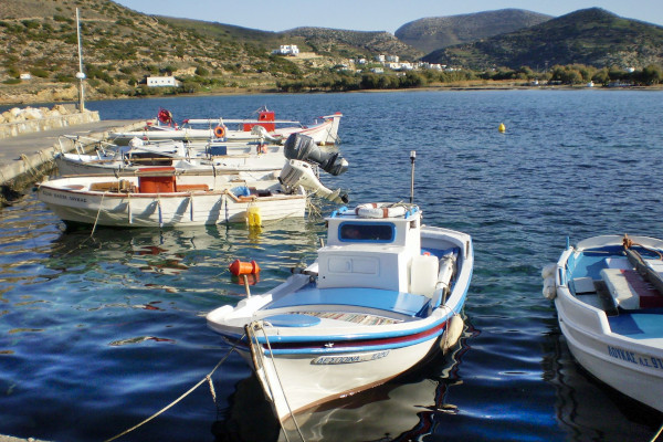 Μικρά αλιευτικά σκάφη αγκυροβολημένα στο λιμάνι του Γαλησσά και οι λόφοι στο φόντο .
