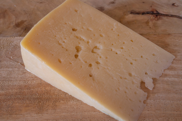 Ένα τοπικό προϊόν της Σύρου, το κίτρινο τυρί Σαν Μιχάλη, πάνω σε τραπέζι.  