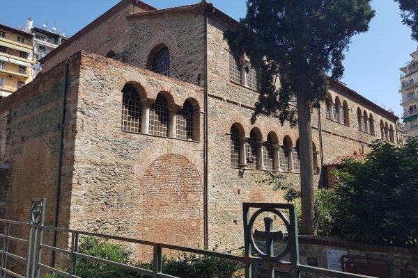 Μια πλινθόκτιστη βυζαντινή εκκλησία με λίγα τοξωτά παράθυρα ανάμεσα σε πολυκατοικίες.