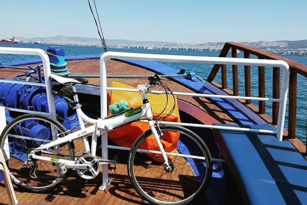 Ένα ποδήλατο δεμένο στο κατάστρωμα ενός ferry boat για Περαία & Νέους Επιβάτες με ξύλινα μέρη - μερικά βαμμένα σε μπλε.