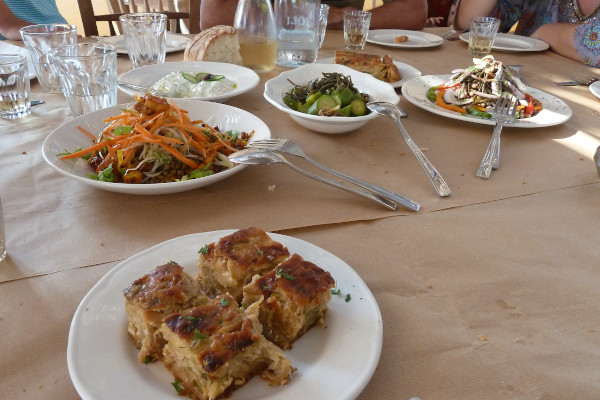 Σαλάτες και τοπικά πιάτα και ψωμί σε ένα τραπέζι σε μια ταβέρνα της Τήνου.