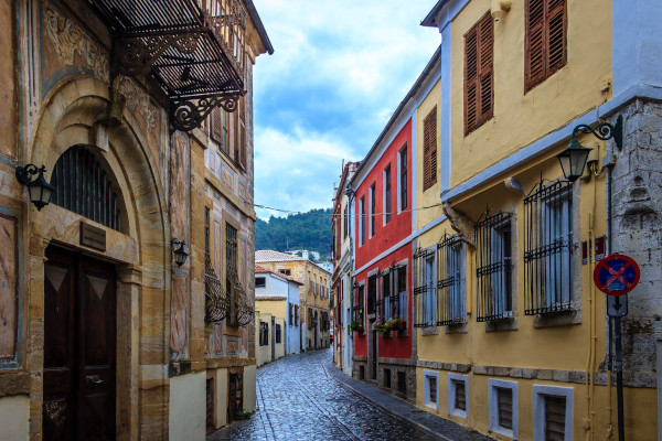 Ένας στενός πέτρινος δρόμος ανάμεσα σε πολύχρωμα κτίρια με παραδοσιακή αρχιτεκτονική στην παλιά πόλη της Ξάνθης.