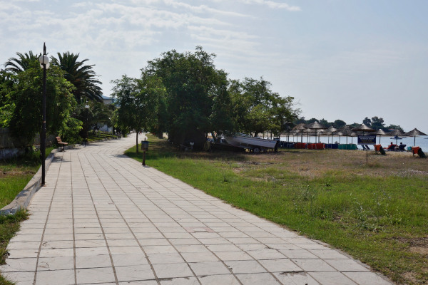 Ένα πλακόστρωτο μονοπάτι στον παραλιακό δρόμο της Γερακίνης που περνά πολύ κοντά στην αμμώδη παραλία.